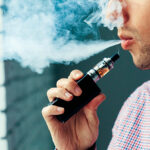 Close up on a man exhaling vapor from an electronic cigarette